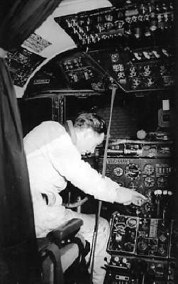 1950s A Pan Am mechanic working in the cockpit of a DC4 Clipper at Berlin Tempelhof airport.